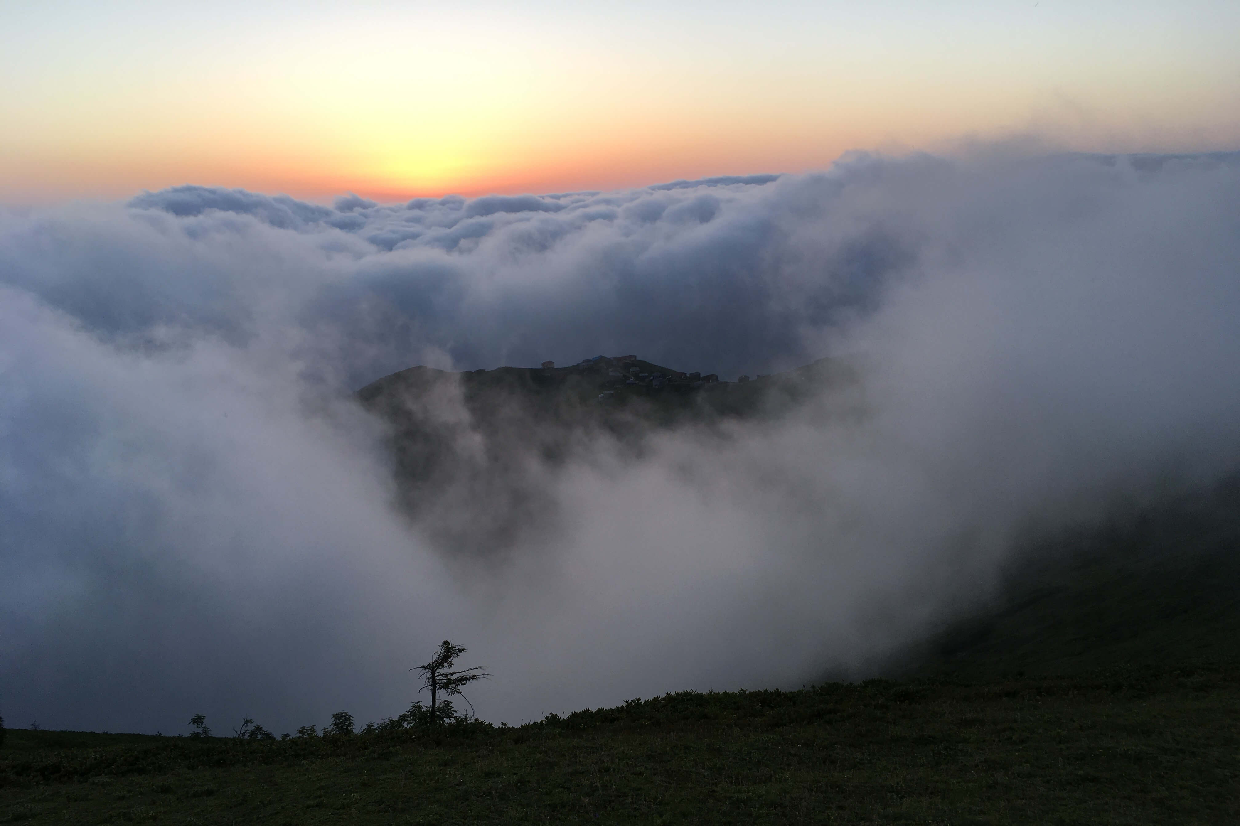 hills and a village above the clouds